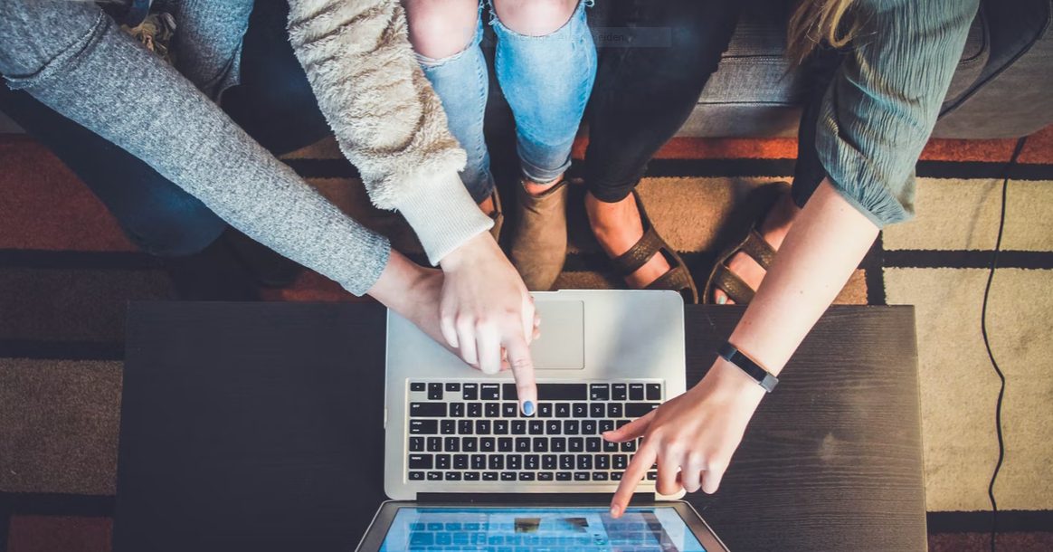 Drei Frauen arbeiten gemeinsam an einem Laptop. Auch beim Programmkonvent werden wir gemeinsam in kleinen größeren Runden diskutieren.